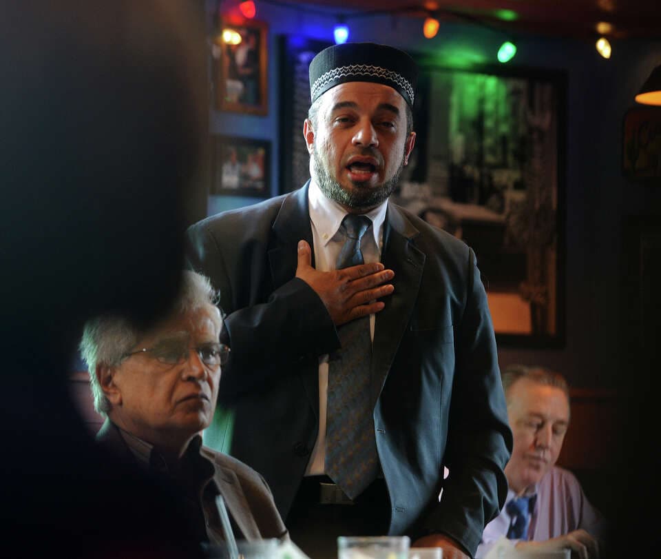 Nidal Alsayyed with a hand over his heart while speaking